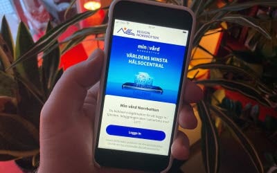 Person som håller i en mobil i ett kök.